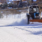 Snow removal machine clears the way in a cottage town after heavy a snowfall. Snow clearing.